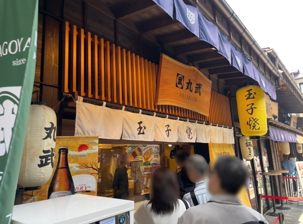 千客萬來內的人氣玉子燒名店『丸武』店面，門前可見排隊人潮。