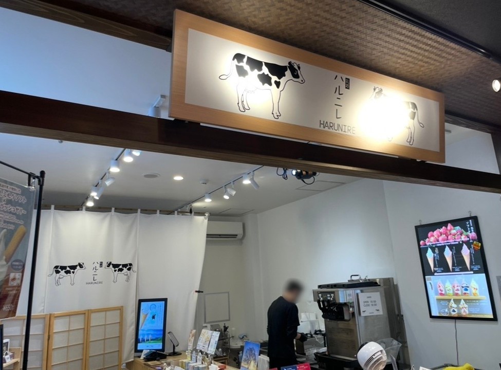 千客萬來的霜淇淋店『哈魯尼雷』店面，明亮白色系的內裝與電子菜單相當醒目。