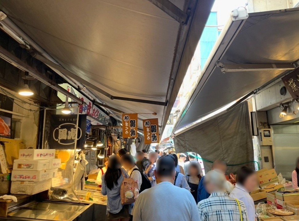 築地場外市場的街景，兩側排列著販售海鮮與食材的熱鬧店舖。