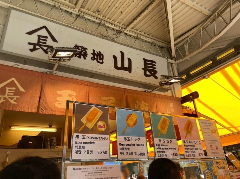 築地玉子燒店『山長』的店面，販售多款玉子燒串的熱鬧攤位。