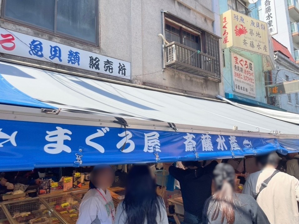 斎藤水產的店面，藍色遮棚下聚集著前來選購鮮魚的民眾。