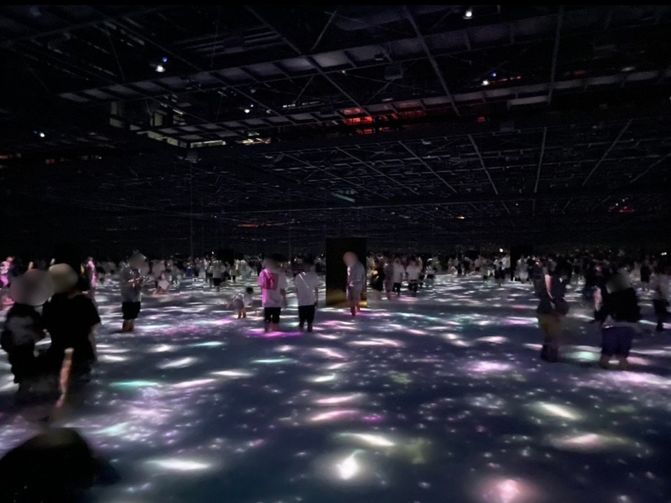teamLab Planets 豊洲の「光の水面」エリア。床一面に広がる光が水面のように揺らめき、来館者が光の反射の中を歩く没入型デジタルアート体験の様子。