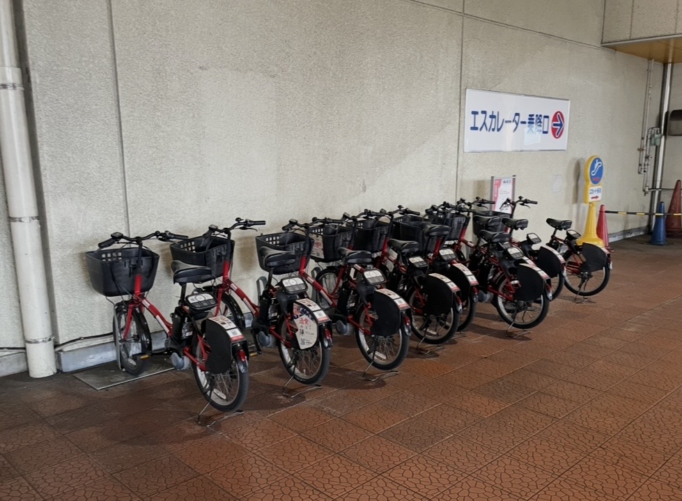 佐渡汽船フェリーターミナルに並ぶレンタサイクルのポート。赤い電動アシスト自転車が整然と並んでいる様子。