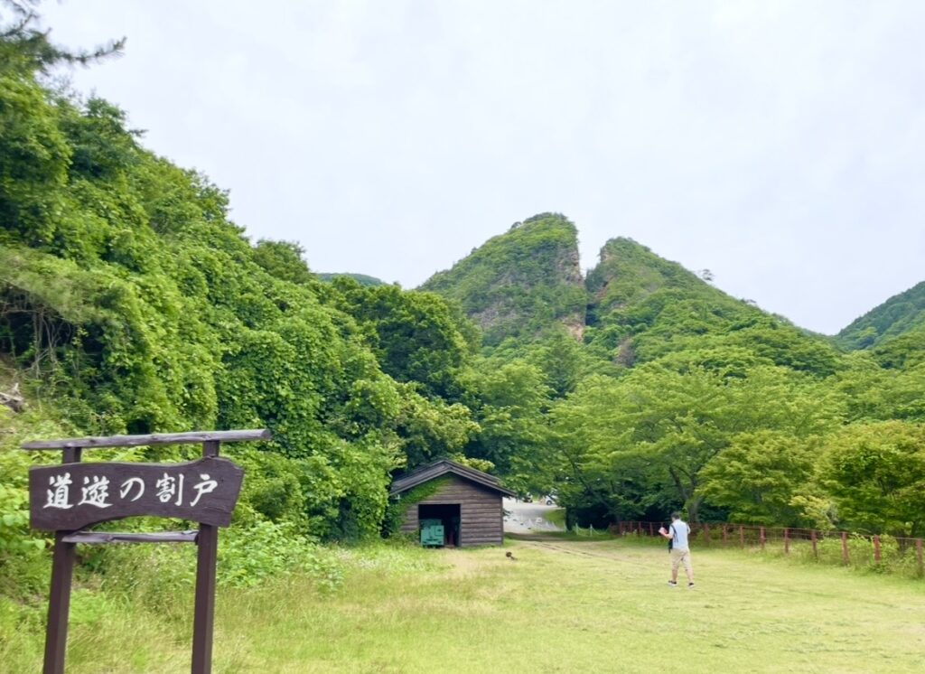 佐渡金山の象徴・道遊の割戸の景観。
緑に覆われた岩山が大きく裂けた迫力ある姿を捉えた写真で、世界文化遺産・佐渡金山を代表する名所の様子。