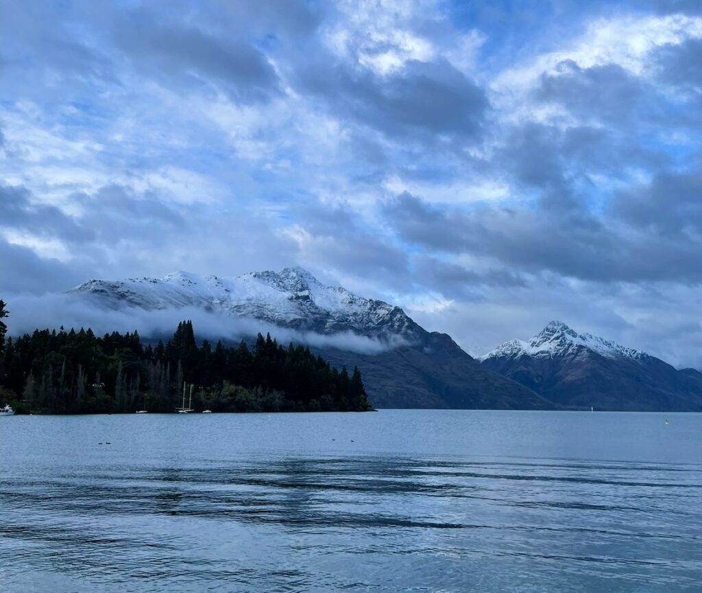 クイーンズタウンの朝に広がる湖と雪山の絶景。ミルフォードサウンドへ向かう出発地の静かな冬景色