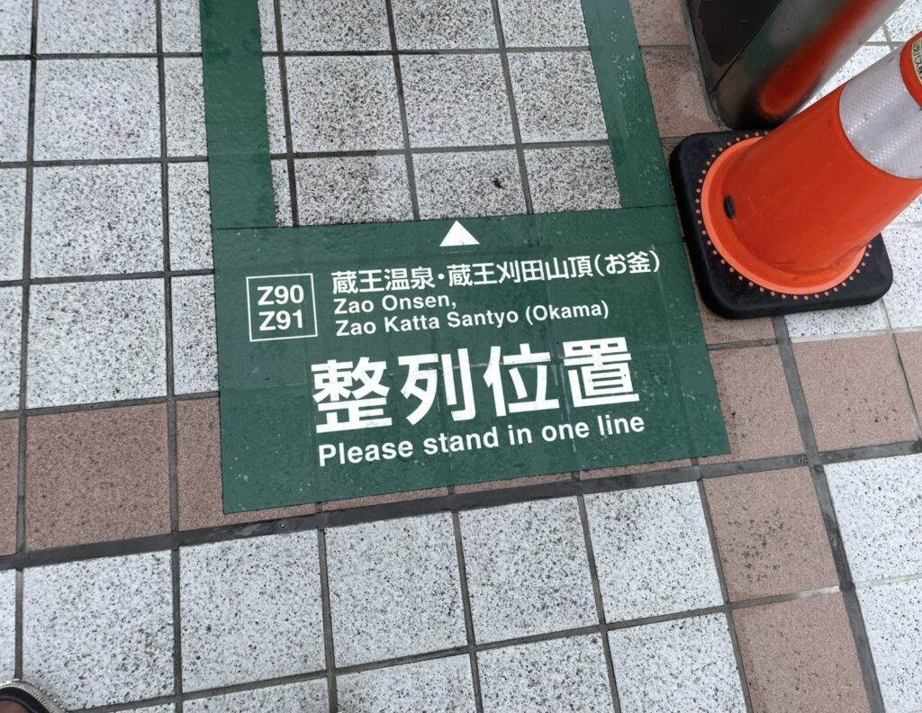 山形駅前にある蔵王温泉・蔵王刈田山頂（お釜）行きバスの整列位置案内サイン。Z90・Z91の乗り場番号が表示された床面の標識と、近くに置かれたコーンが写る、蔵王行きバス乗り場の目印。