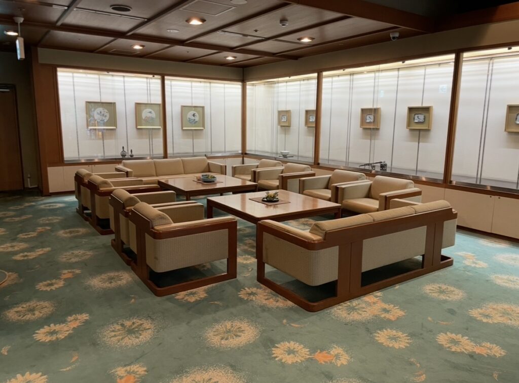 ほほえみの宿 滝の湯の館内に並ぶソファー席。落ち着きあるインテリアと柔らかな照明が特徴のスペースの写真。