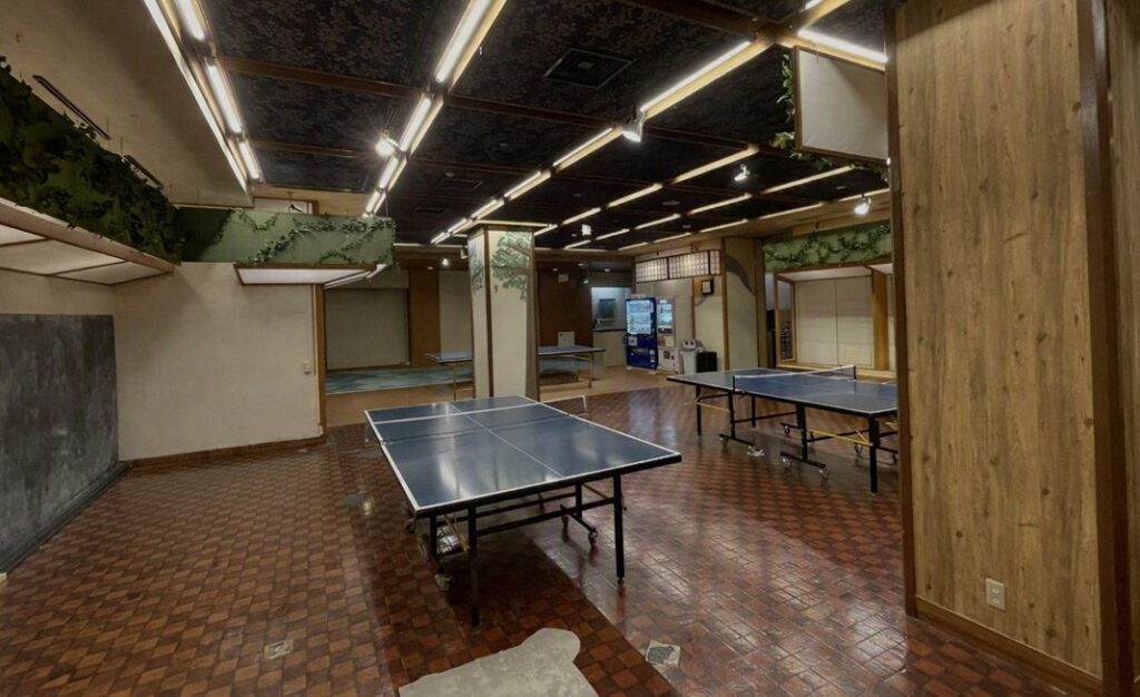ほほえみの宿 滝の湯の館内にある卓球ルーム。複数の台が並ぶ明るいレクリエーションスペースの写真。