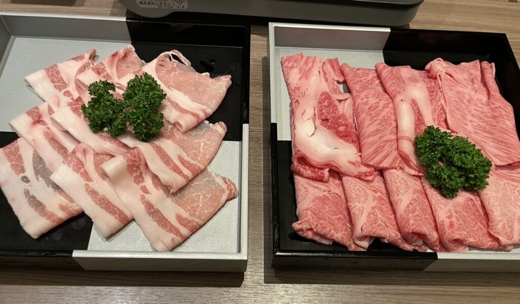 ほほえみの宿 滝の湯で提供される山形牛と米沢豚の盛り合わせ。霜降りの牛肉と豚バラ肉が並ぶ、しゃぶしゃぶ用の肉皿の写真。