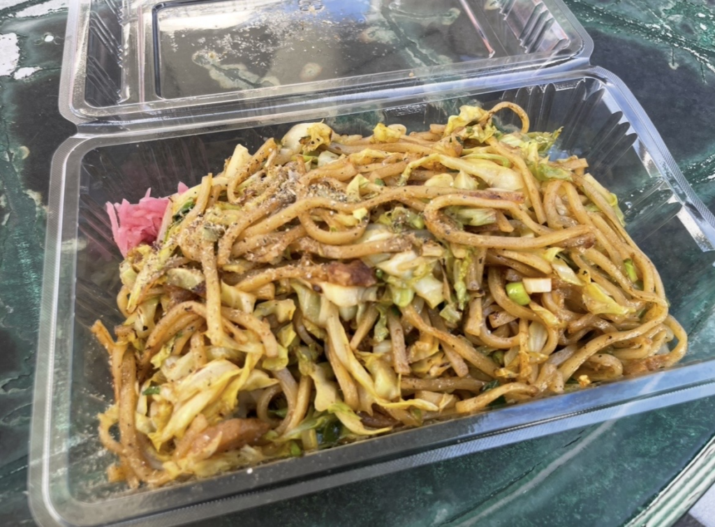 富士宮炒麵的外帶餐盒,Q彈麵條搭配高麗菜與油渣,撒上香味粉並附有紅薑,是富士宮最具代表性的名物料理。