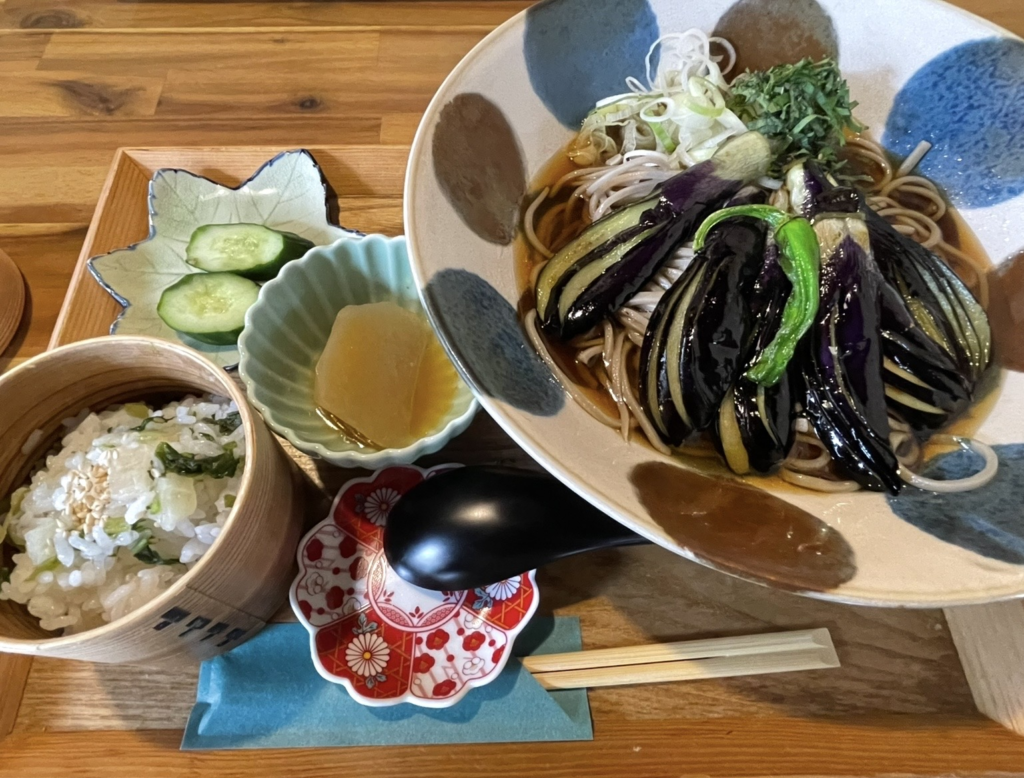 炸茄子蘿蔔泥蕎麥麵的擺盤。
香酥的茄子與細緻的大根泥覆在蕎麥麵上，青辣椒與各式藥味增添了和食的色彩。