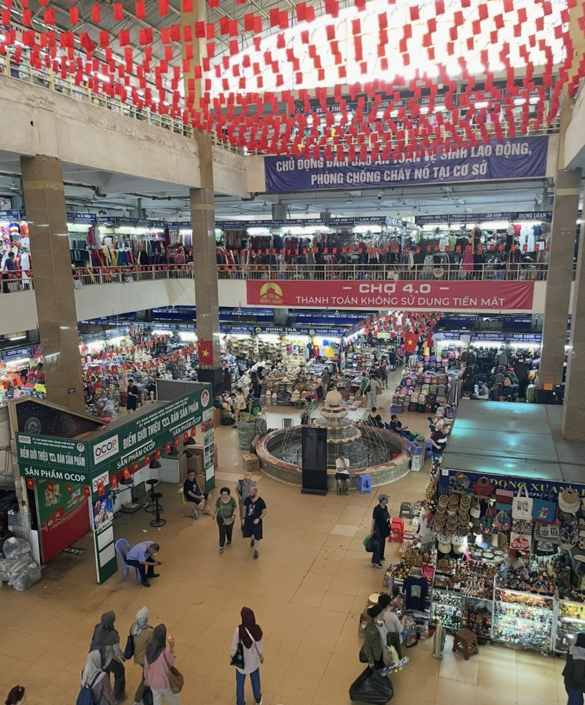 河內同春市場內,多個攤位與往來的購物人潮交織出的熱鬧景象