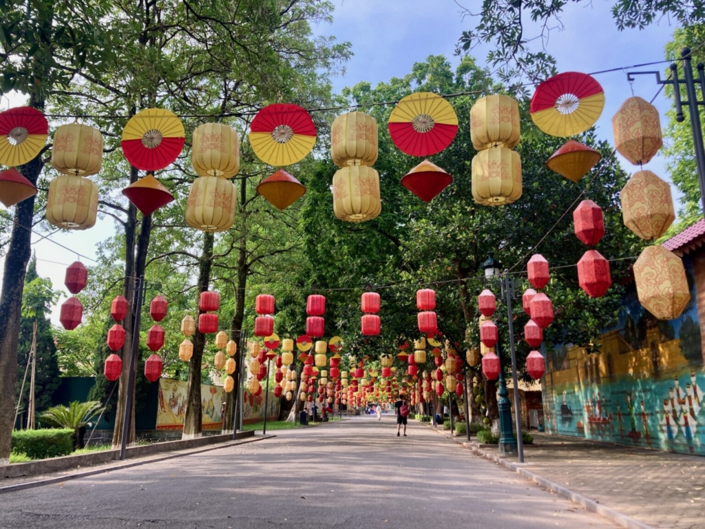 昇龍皇城遺址的林蔭步道上懸掛著色彩鮮豔的燈籠與雨傘,構成華麗的街景