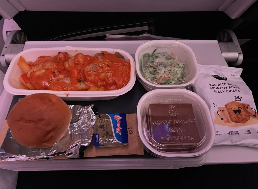 紐西蘭航空經濟艙的機上餐點照片。
主餐、沙拉、麵包與甜點整齊擺放在托盤上。