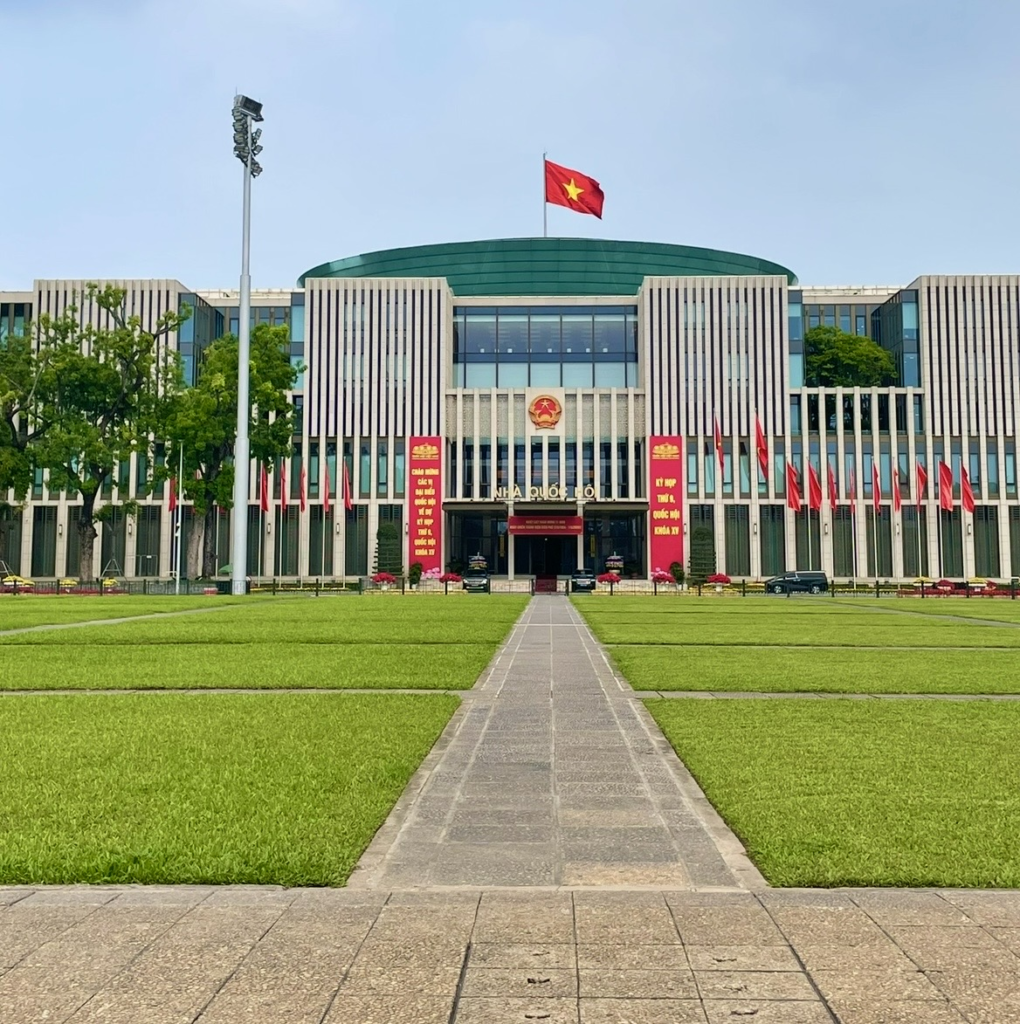河內越南國會議事堂前,白色柱體的現代建築與懸掛國旗的正面廣場景致
