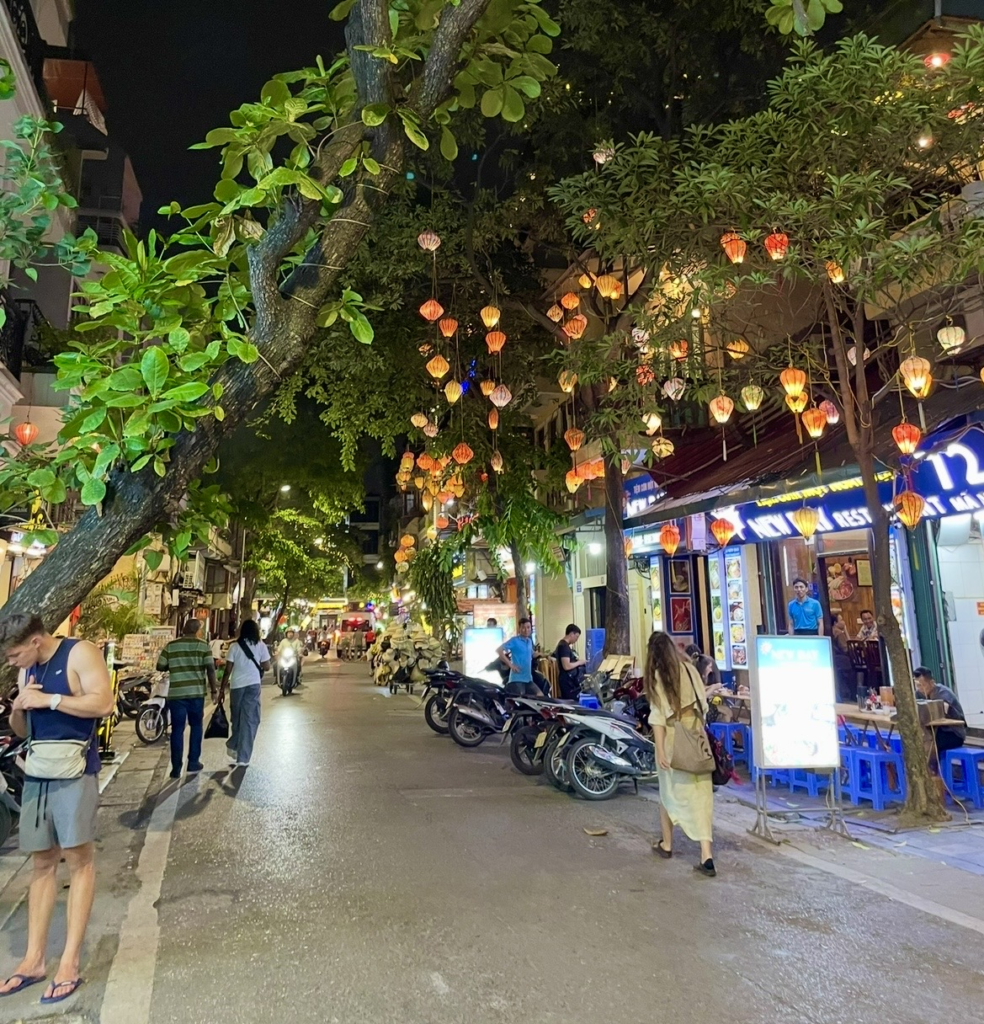 河內舊城區夜晚,色彩鮮豔的燈籠點亮街道,攤販與機車排列的熱鬧景象