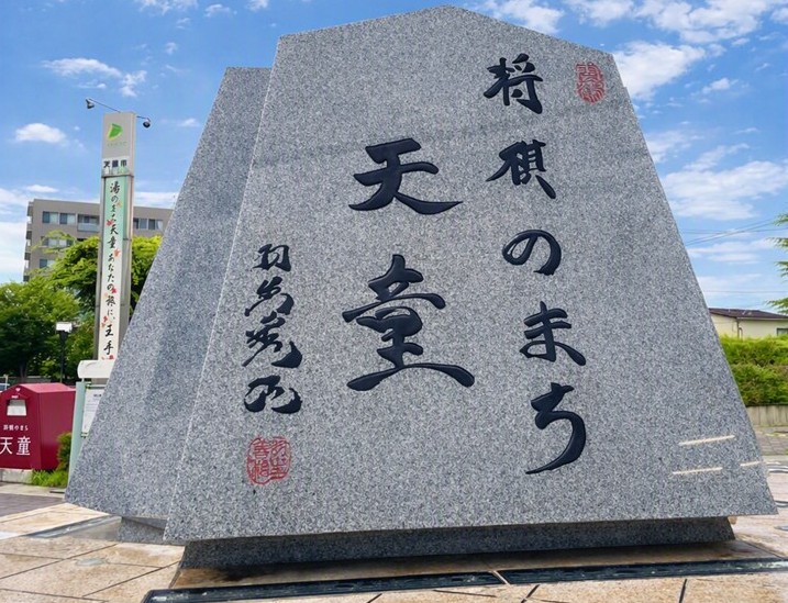 天童市の「将棋のまち」石碑。青空の下で将棋文化を象徴する碑が立つ様子を写した写真。