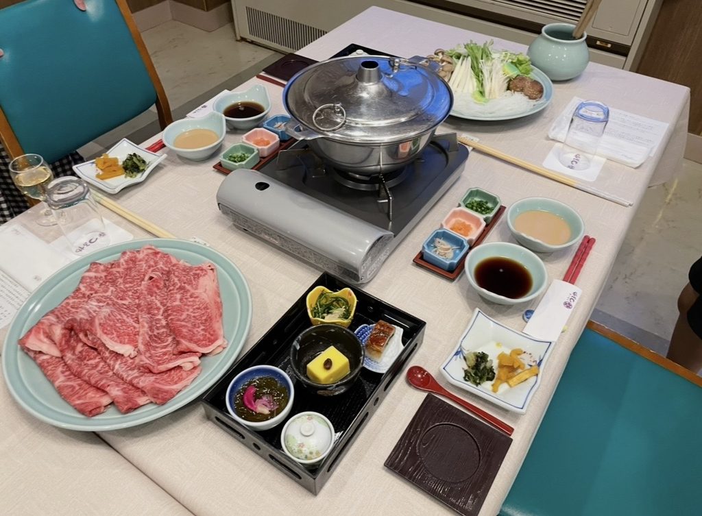 五感の湯つるやの夕食で提供される蔵王牛のしゃぶしゃぶ膳。霜降り肉、野菜、きのこ、鍋が整然と並び、蔵王温泉の旅館らしい贅沢な和食会席の雰囲気が伝わる。