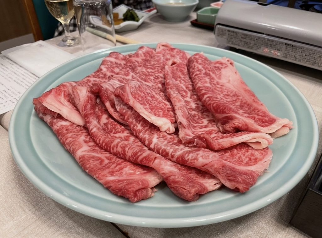 五感の湯つるやの夕食で提供される蔵王牛の霜降り肉。美しく並んだ薄切り肉がテーブルに用意され、しゃぶしゃぶやすき焼きで味わえる高品質な蔵王牛の魅力が伝わる。