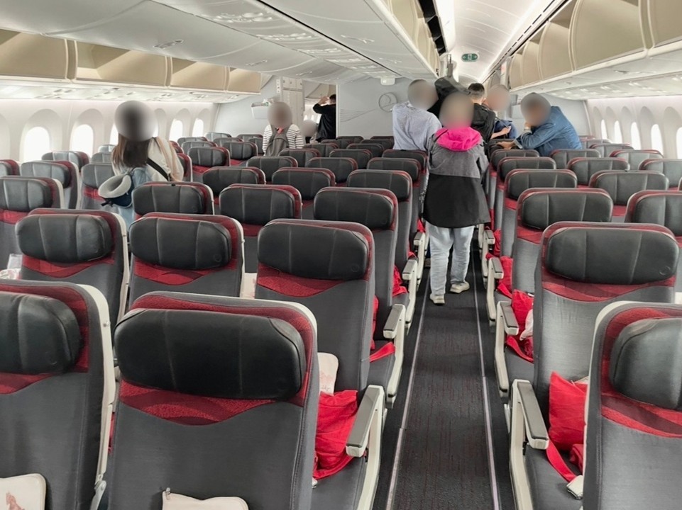 The economy‑class cabin of Turkish Airlines with a 3‑3‑3 seat layout.
Passengers are storing their luggage and getting ready for departure, capturing the boarding atmosphere inside the aircraft.