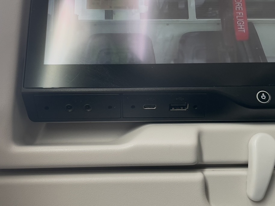 ターキッシュエアラインズのシート背面のモニタ下部に備えられたUSBポート。USB‑AとUSB‑C、ヘッドフォン端子が並び、機内での充電や接続が快適に行える仕様になっている。