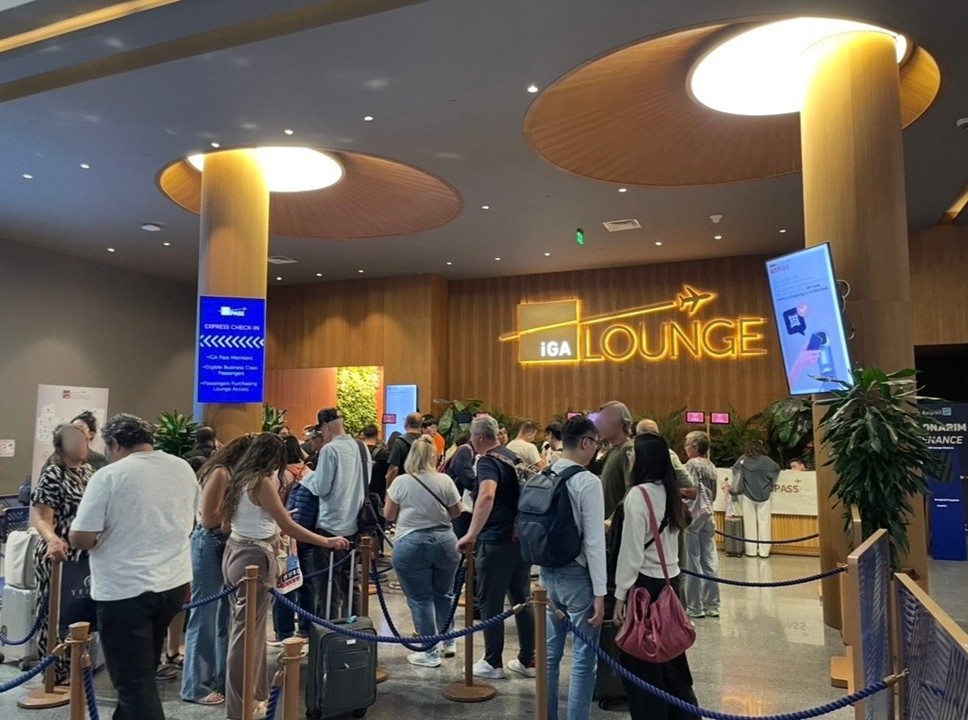 伊斯坦堡國際機場 IGA 貴賓室的接待區，旅客在明亮的入口前排隊，入口處可見設有指示的報到櫃台。