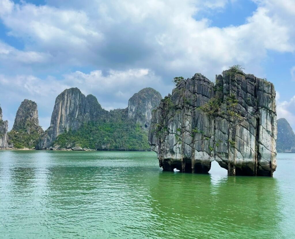下龍灣象徵性的夫婦岩（香爐島），兩座並立於海面的石灰岩奇岩倒映在平靜水面上，呈現下龍灣神秘又優美的景色。