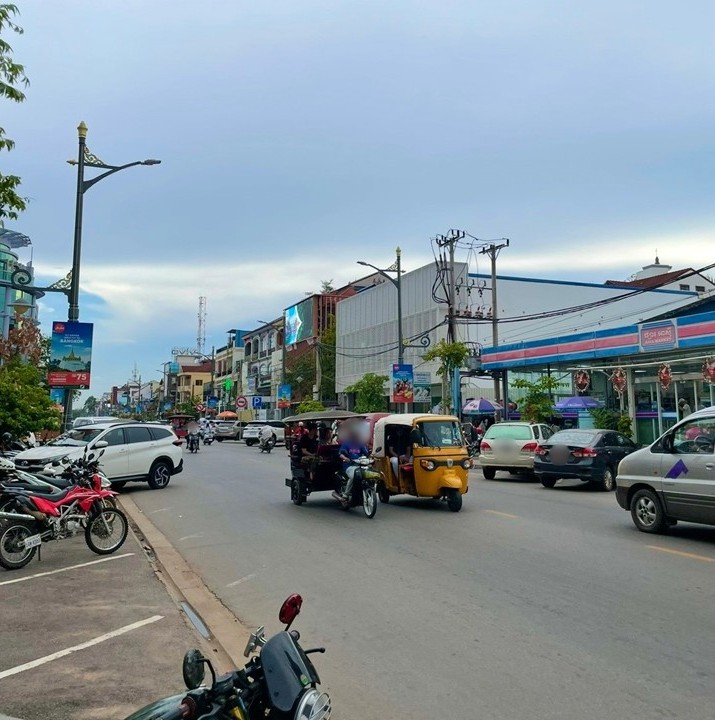 柬埔寨暹粒市中心的街景，嘟嘟車與機車行駛在乾淨的馬路上。