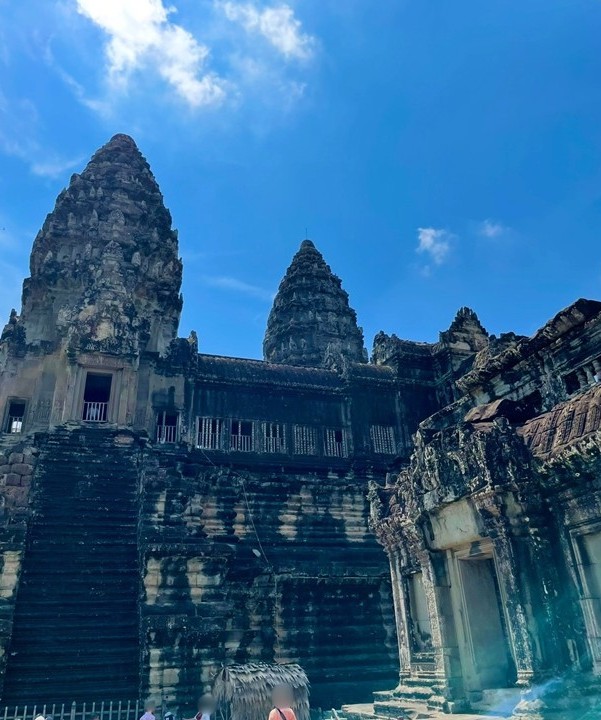 吳哥窟（Angkor Wat）的第三迴廊與中央祠堂，藍天之下仰望宏偉的石造建築與陡峭石階。