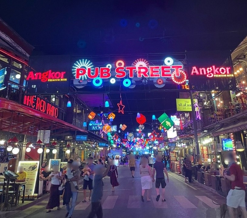 暹粒酒吧街入口處閃爍的霓虹燈招牌與熱鬧的夜生活景象。