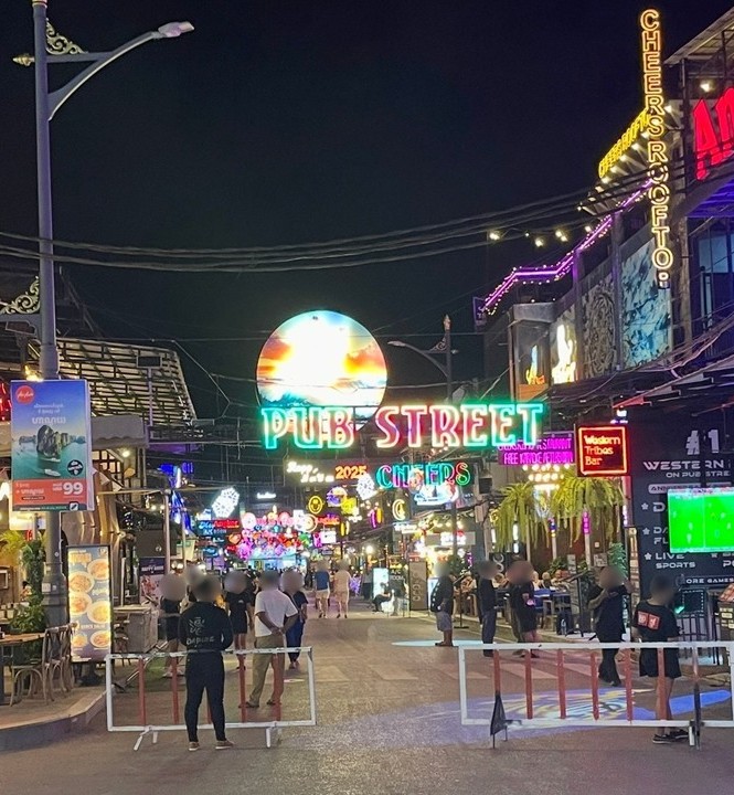 暹粒酒吧街中央閃耀的圓形大霓虹燈與CHEERS等夜生活酒吧街景。