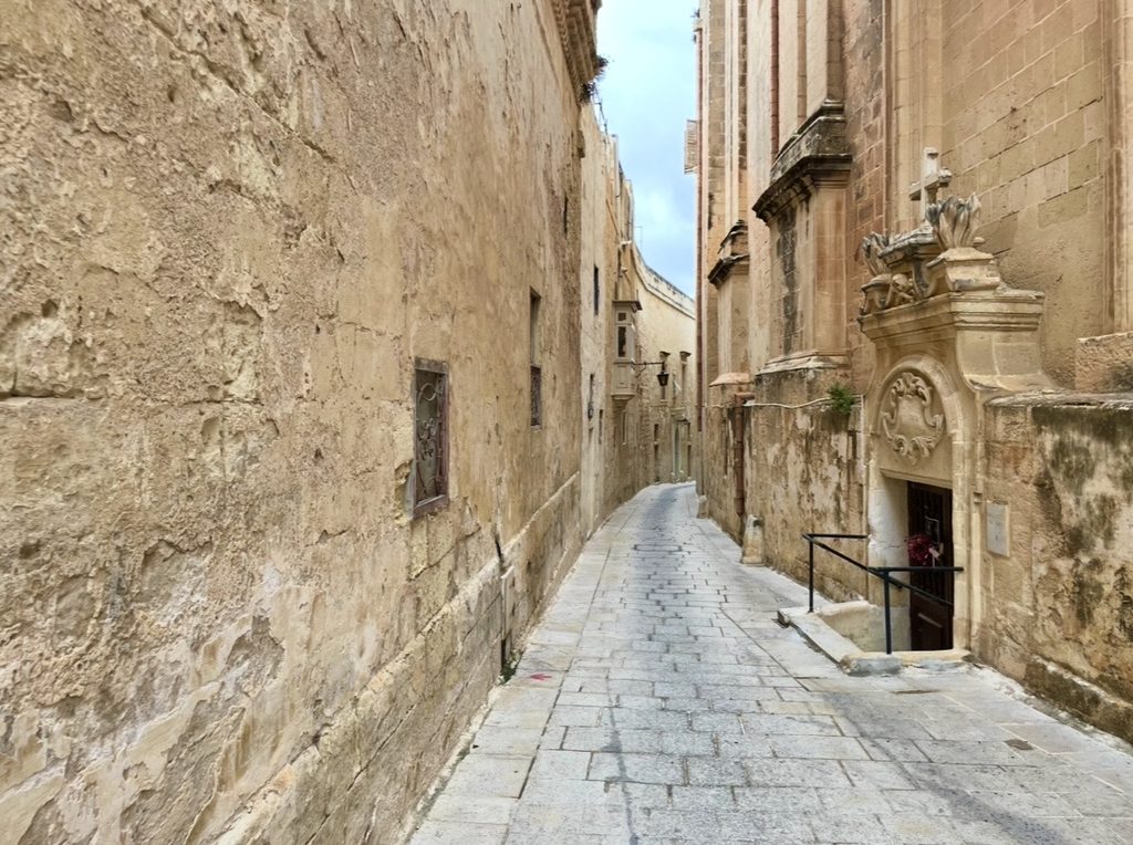 マルタのイムディーナ観光で出会う重厚な石壁に挟まれた中世の面影が残る細い路地裏の景観