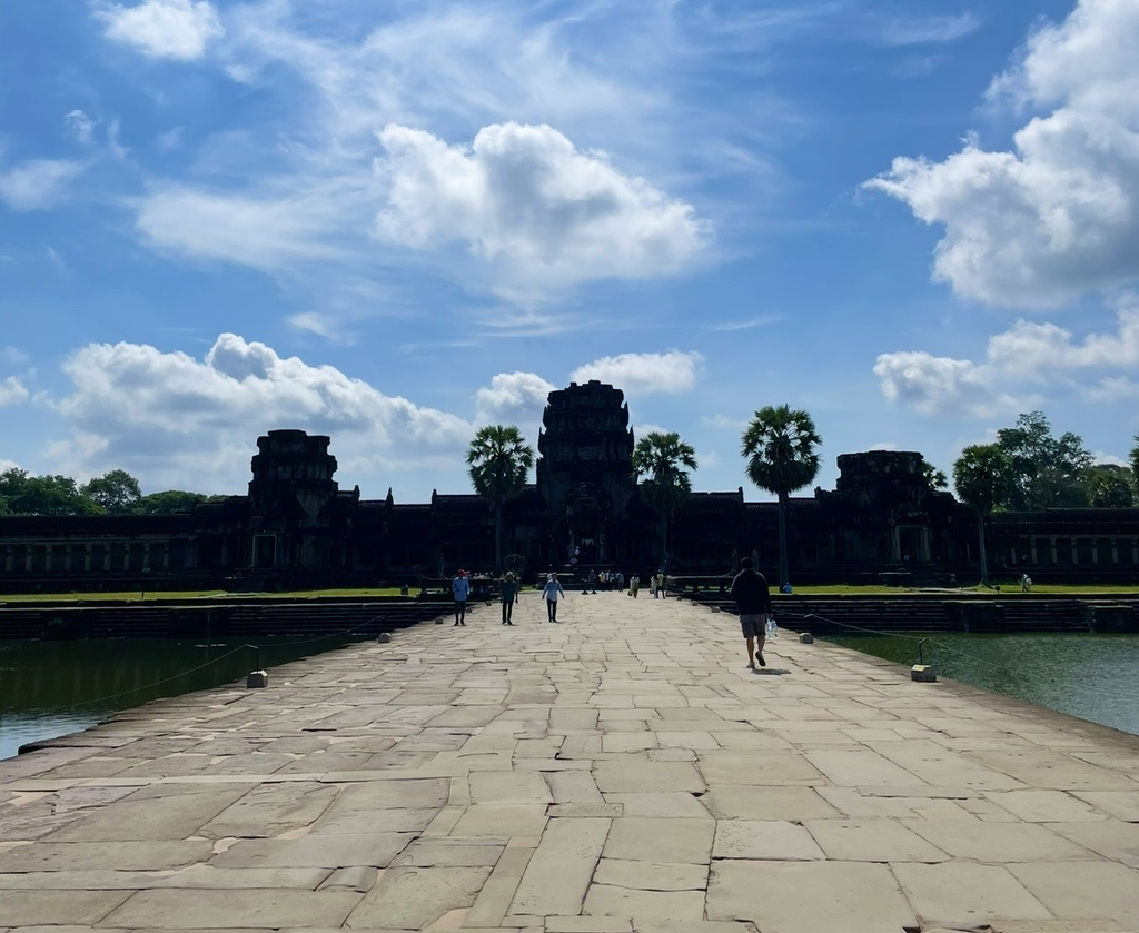 吳哥窟（Angkor Wat）漫長的西參道，藍天白雲下通往中心神廟的石板路與前行的遊客。